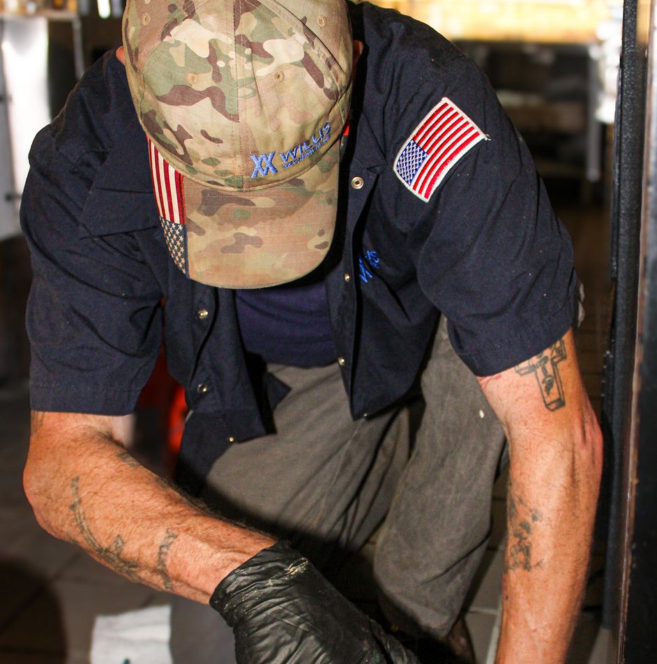 Willis Mechanical technician working on a commercial floor drain