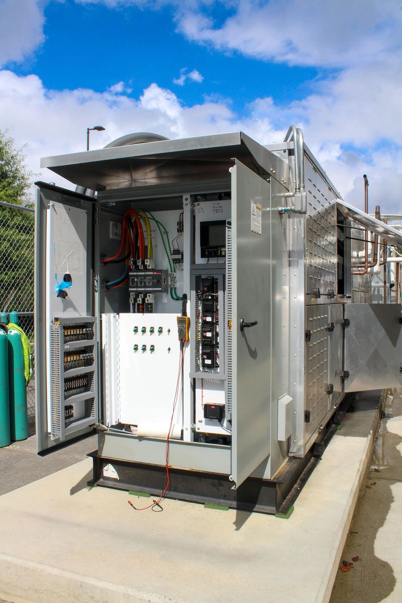 Packaged refrigeration unit on a concrete pad with its control cabinet open